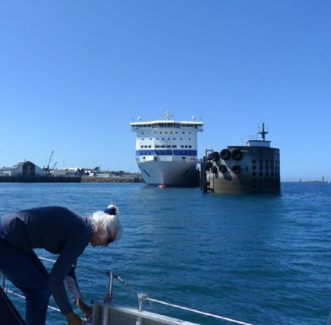 Invaart Roscoff. De ferry is gereed om uit te varen, maar wacht even tot we voorbij zijn. Ans hangt net de stootwillen op.