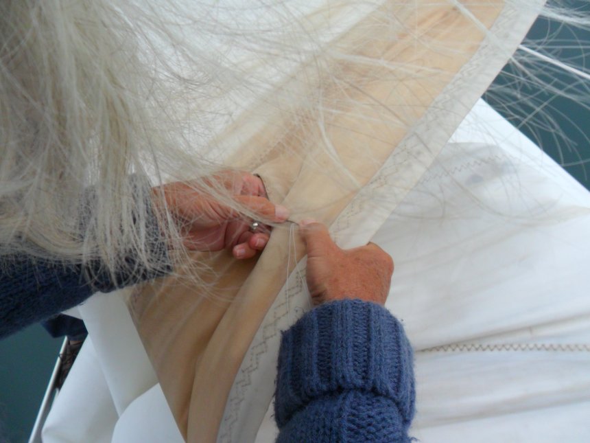 Ans repareert een losse naad in de UV-strip van de genua