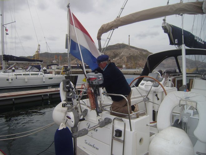 Poetsen van de RVS-buizen. Op de achtergrond zie je de hoge toren, die als baken dient voor de invaart van de haven van Cartagena.