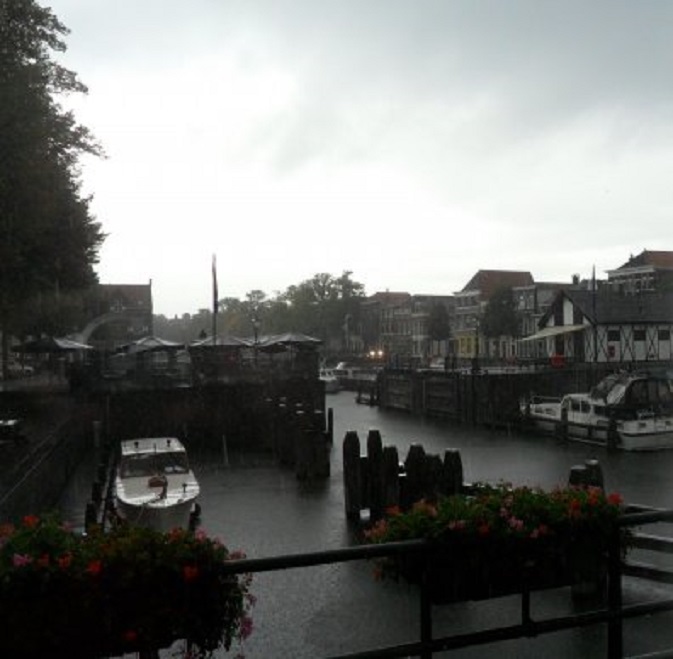 Regenbui over de Lingehaven. Links op de voorgrond de Dudok, die werd verhaald vanwege de opbouw van het podium voor de Lingehavenconcerten