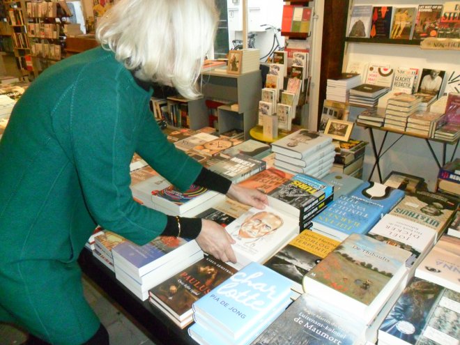 Emmy van Boekhandel De Mandarijn legt het JS-boek op de tafel, naast het 3e deel van mijn romancyclus.
