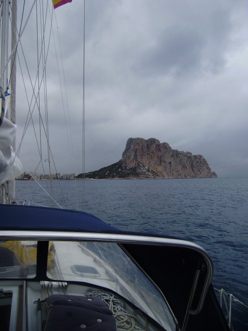 De Peñón de Ifach steekt als een grote, rotte kies op uit zee. Links ervan de haven van Calpe