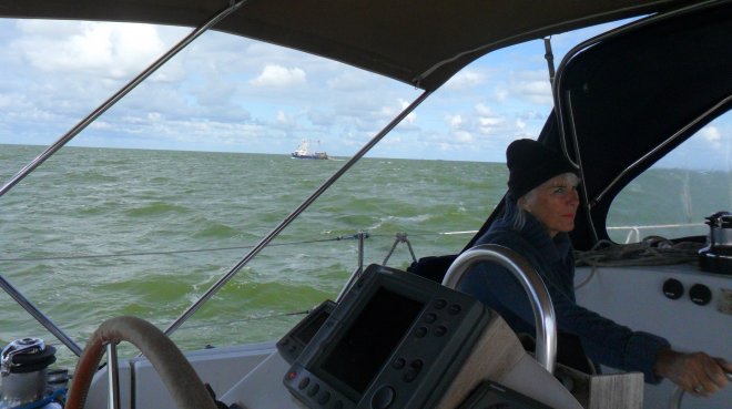 Harde tegenwind op weg naar Kornwerderzand. Op de achtegrond een visser. Ans is niet blij.