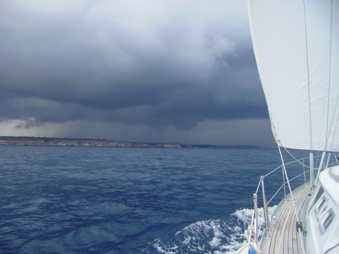 Nadat we Punta Salinas passeren, de zuidoostpunt van Mallorca, en naar het noorden zeilen, komt er een flinke onweersbui op ons af.