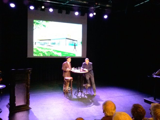 Wethouder Arjen Rijsdijk (rechts) wordt in Theater De Peeriscoop geïnterviewd door Paul Mulders, voorzitter van de Historische Vereniging Oud-Gorcum. Op de achtergrond een projectie van de afzichtelijke pisgele hoteldoos van Voet en Den Braven.