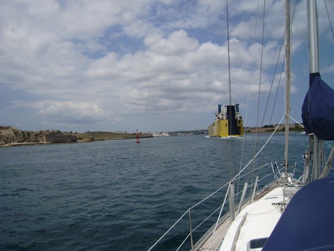 Achter een ferry aan varen we de lange, diepe haven van Mahón (hoofdstad van Menorca) binnen, op weg naar de kade van Sunseeker.