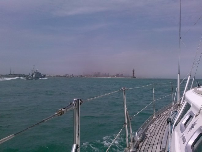 Met een boot van de Franse kustwacht varen we op naar de havenhoofden van Duinkerken. De petrochemische industrie werpt een vieze stinklucht uit.