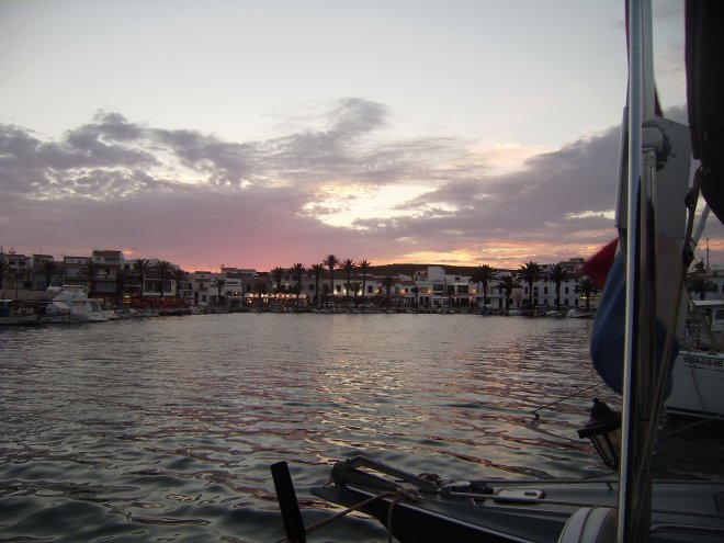 De avond valt boven de kade in Fornells aan het eind van een zonovergoten dag. Elke dag hier is overigens zonovergoten.