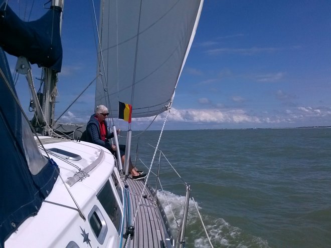 Anna haalt bij Cadzand het Belgisch gastenvlaggetje in. Rechts in de verte de duinkust van Walcheren.
