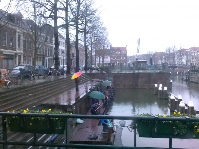 Viswedstrijd op de steigers in de haven, vanmorgen in de regen. Waar ze lol in hebben?