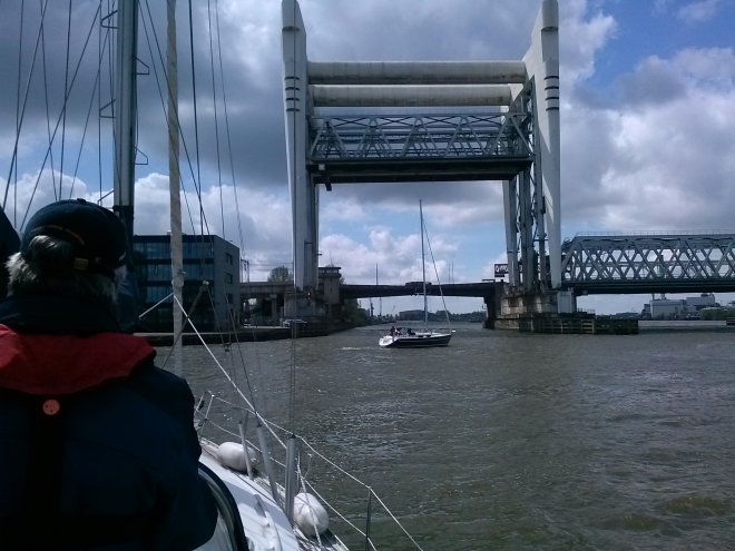 Voor de spoor- en verkeersbrug over de Oude Maas bij Dordrecht ligt al een jacht te wachten. De hefbrug gaat al omhoog.