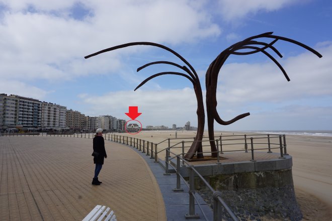 De boulevard van Oostende. Vooraan een beeld van Patrick Steen, op de achtergrond (rode pijl) de Koninklijke Villa.