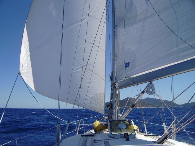 Voor de wind naar Isola del Giglio, dat je kunt zien onder de giek
