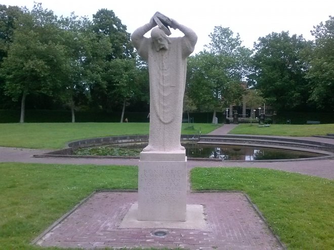 Het beeld van Bonifatius die zijn hoofd beschermd met een bijbel tegen de stokslagen (Gerrit Bolhuis, 1962) te Dokkum.