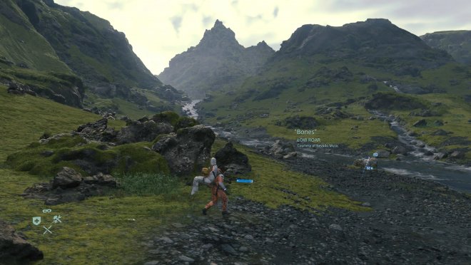 Death Stranding. Mijn avatar Sam Porter Bridges brengt het lichaam van een overleden president van de VS naar een crematorium.