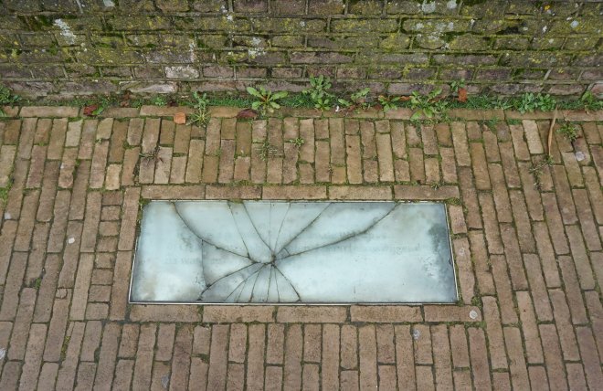 Nummer 21 van de Gorcumse Poëzieroute bij de coupure van Buiten de waterpoort. De glasplaat is stuk geslagen.