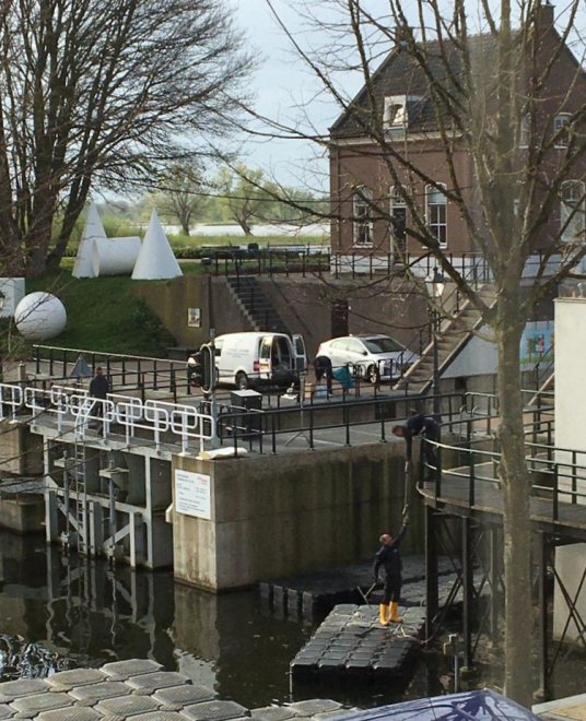 Vandaag worden de palen van de voetgangersbrug om ons huis (rechts) geschilderd (foto: Emmy van Ingen)
