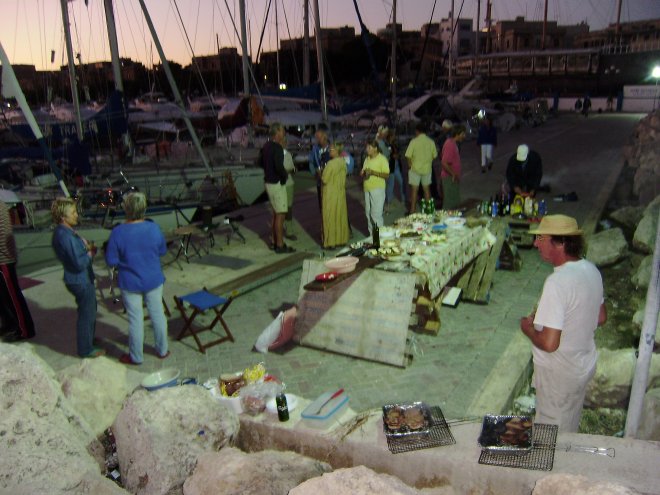 Zeilersbarbecue op de havendam. Als je goed kijkt zie je achteraan rechts de Black Pearl liggen. De man met het hoedje rechts is Hugo, de zeiler die de barbecue organiseerde