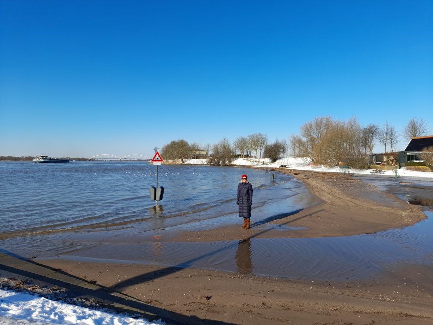 Het bekende strandje aan de Merwede staat bijna helemaal onder water. Links in de verte de Merwedebrug.