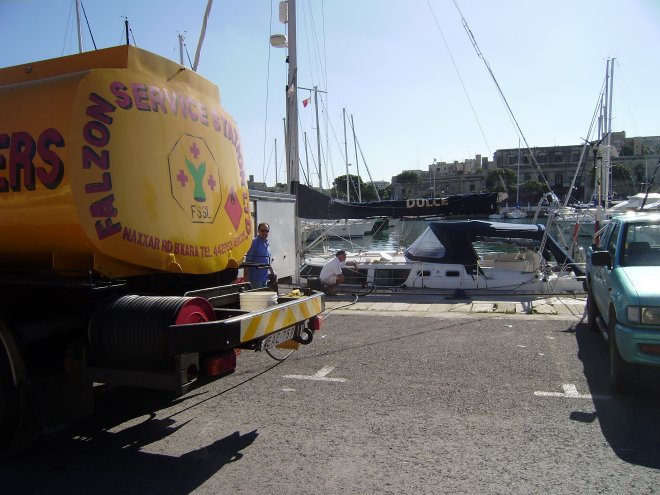 Dulce aan de wal om te bunkeren. Links de tankwagen van Eddy Diesel