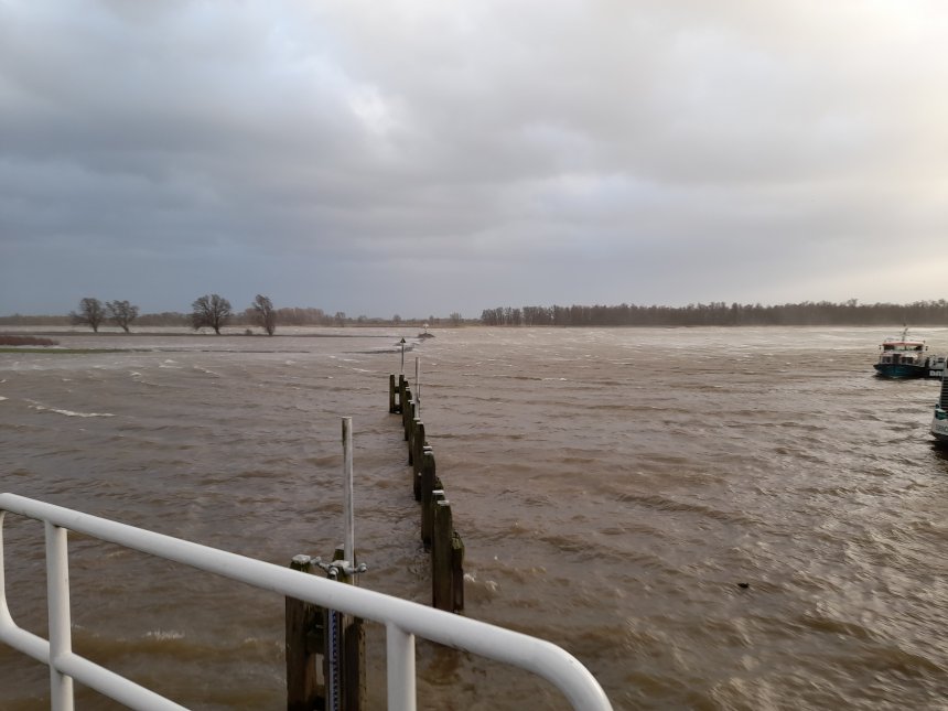 Storm Eunice vanaf het Lingesluisje. In de verte stuift de wind schuim op over de Merwede.