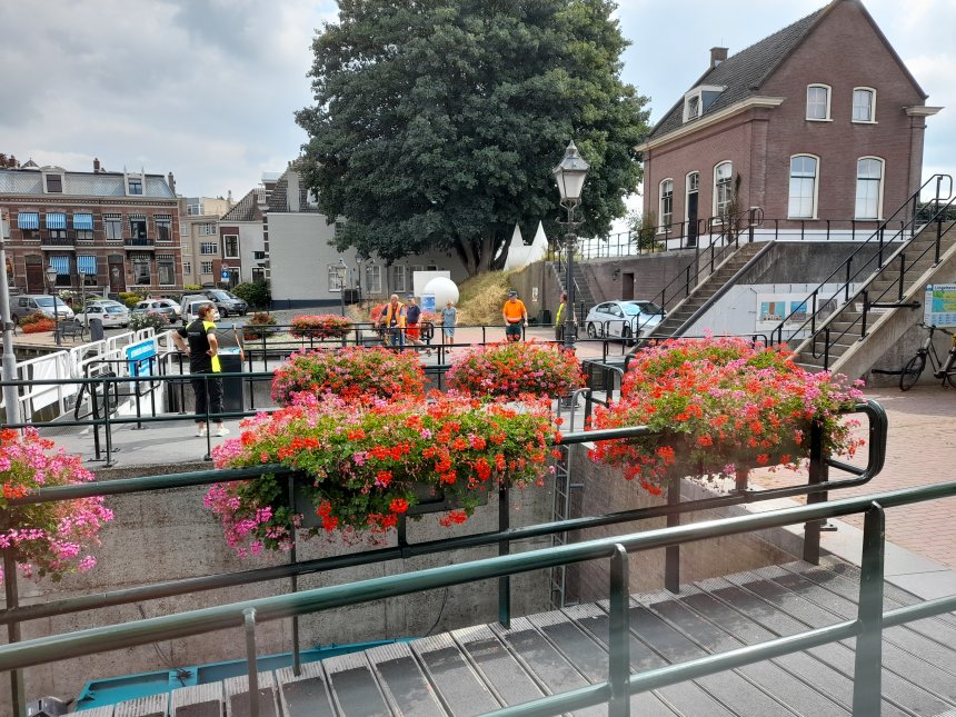 Wolken van geraniums in de bakken op de sluis.