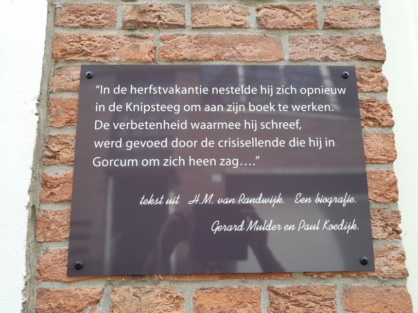 Tekst op Knipsteeg 11, het geboortehuis van Henk van Randwijk. Wie oplet ziet mij met camera in de weerspiegeling..