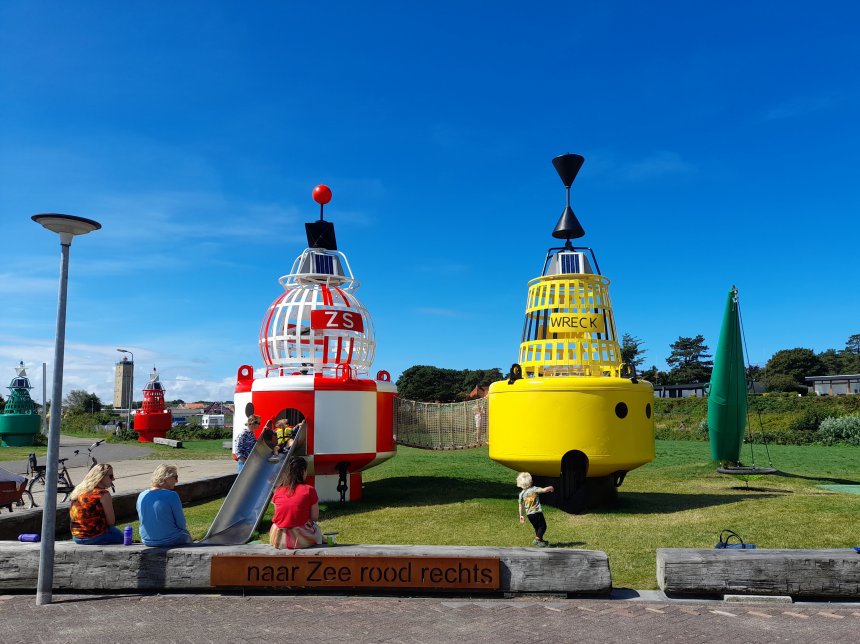Het kinderspeeltplaatsje naast het havenkantoor. Op het bord beneden lees je dat de uitgang linksachter naar het dorp de juiste stand van de boeien heeft.