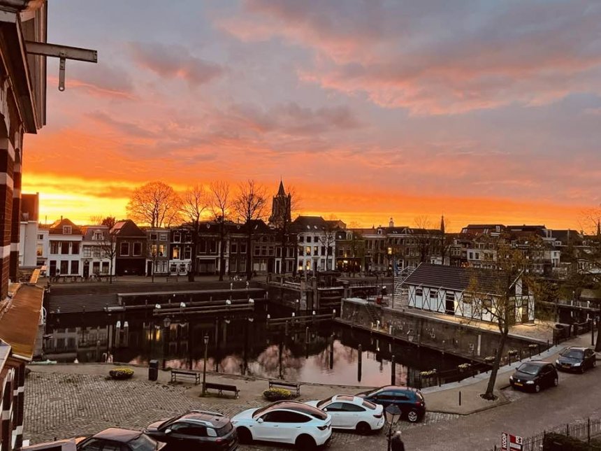 Oranjekleurige avondhemel boven de stad gisteravond door Saharastof in de atmosfeer. Je ziet ook dat het voorzieningengebouw haast klaar is (foto Nel Meeder)