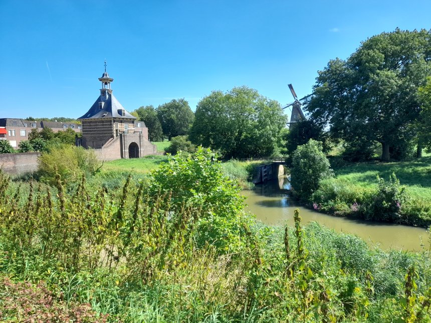 Foto vanaf de Altenawal van het Dalempoortje met rechts tussen de bomen door de molen De Hoop op Bastion 8.