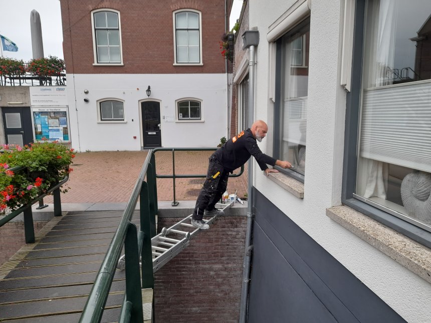 Rob Donker kit de ramen van ons appartement vanaf het voetgangersbrugje.