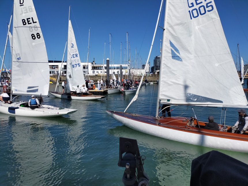 De jachten van de drakenklasse keren terug van hun wedstrijden buitengaats.