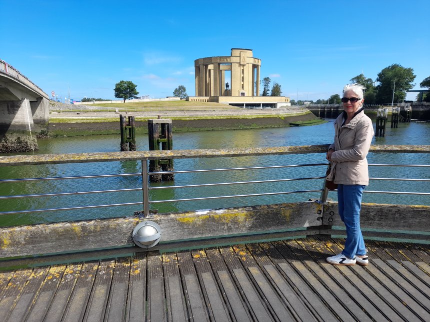 Nieuwpoort. Aan de overkant van het riviertje de IJzer en het sluizencomplex staat het Koning Albert I-monument. Tussen de kolommen door zie je zijn ruiterstandbeeld.