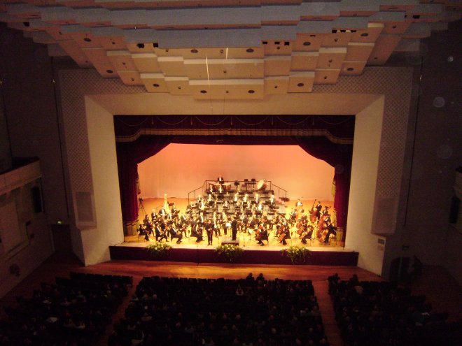 Het Malta Philarmonic Orchestra in de concertzaal van het Mediterranean Conference Centre in Valletta, gefotografeerd vanaf onze plaatsen op het balkon