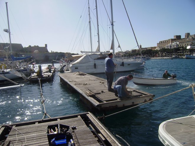 De oude steigerponton wordt weggevaren